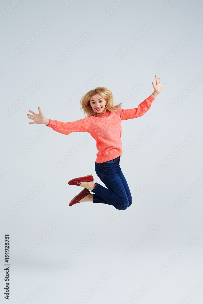 happy blond jumping in studio