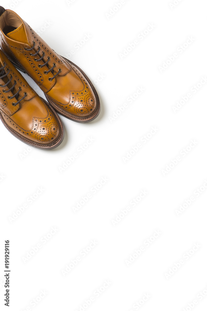 Footwear Ideas. Pair Of Separate Luxury Tan Brogue Boots On Pure White Background with Copy Space Footwear Ideas. Pair Of Separate Luxury Tan Brogue Boots On Pure White Background with Copy Space