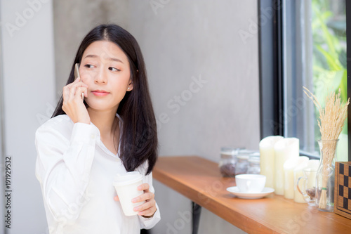 Beautiful young asian woman talking phone and smile in the coffee shop  businesswoman sitting in cafe free time  freelancer female calling telephone  communication concept.