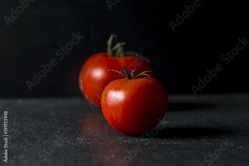 Red tomatoes on dark background