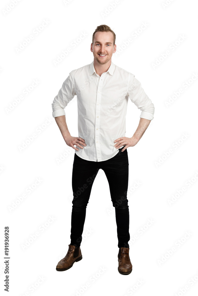 Handsome man standing in front of a white background wearing a white shirt and black jeans looking at camera. Handsome man standing in front of a white background wearing a white shirt and black jeans looking at camera.