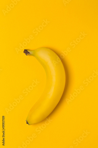 Single fresh, yellow, ripe banana on yellow