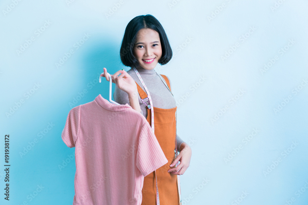 Asian girl designer is showing off the shirt she is designing. Asian girl designer is showing off the shirt she is designing.