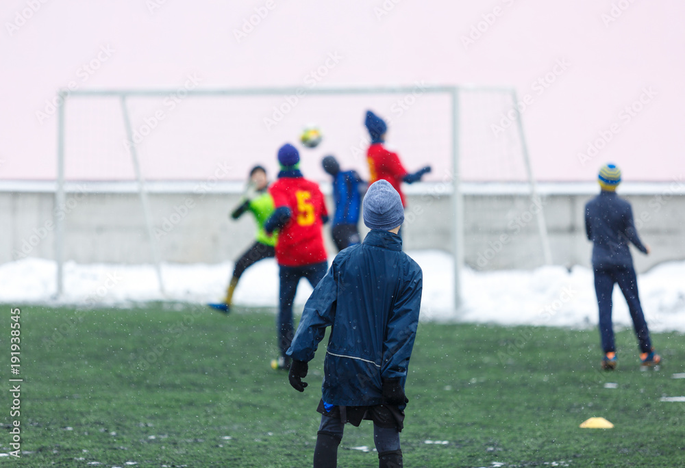 boys  want to score a goal on football tournament at winter