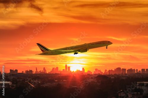 The image of an airplane with a background of sunset light of city building