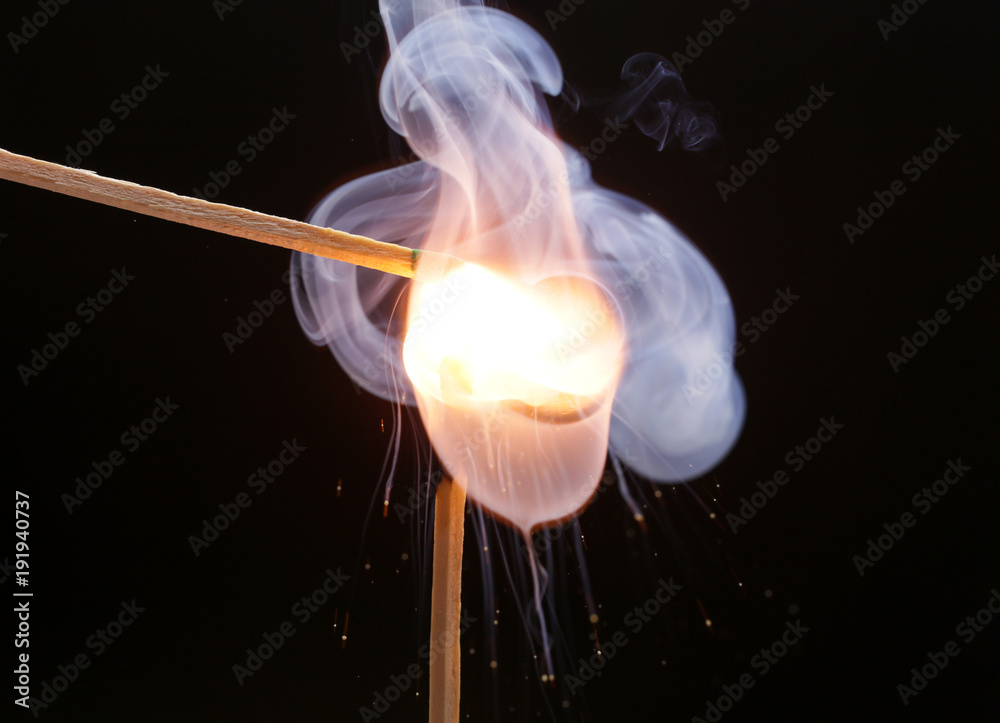 Two igniting matches against black background Two igniting matches against black background