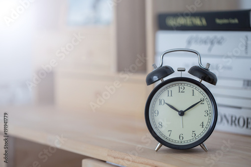 vintage alarm clock on wooden table in the morning with copy space