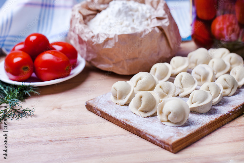 dumplings with meat on a wooden stand - cooking, raw unpeeled dumplings, national Russian, Ukrainian cuisine dumplings with meat on a wooden stand - cooking, raw unpeeled dumplings, national Russian, Ukrainian cuisine