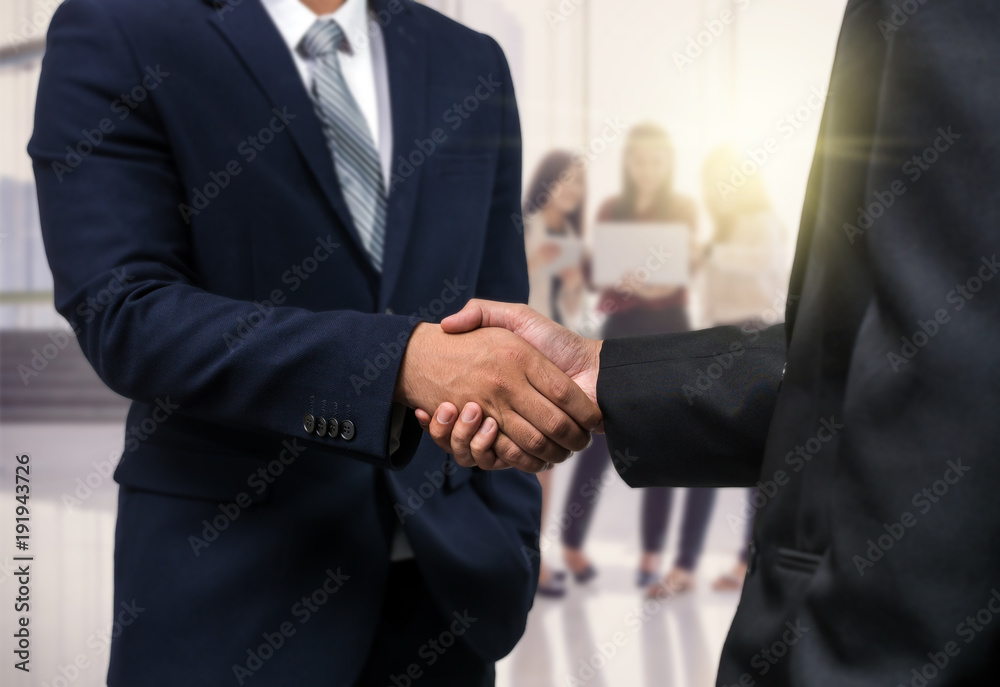 Business shaking hands of partner over the photo blurred of Group Of Asian Businesswomen Meeting In the modern creative Office, business group and partnership concept