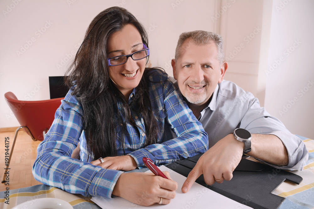 Middle-aged couple working together from home