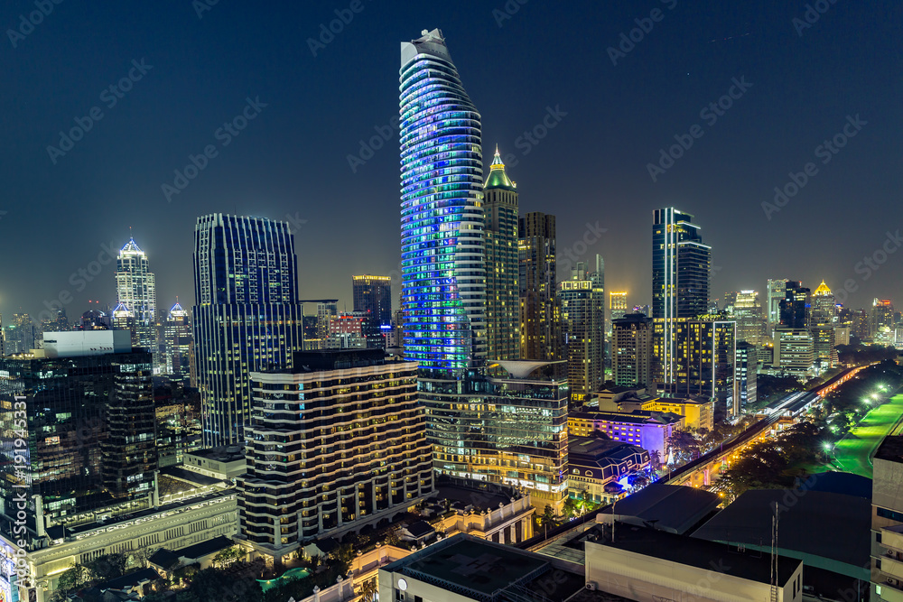 Naklejka premium Cityscape downtown at night, traffic in the city, technology background about modern building on skycraper.