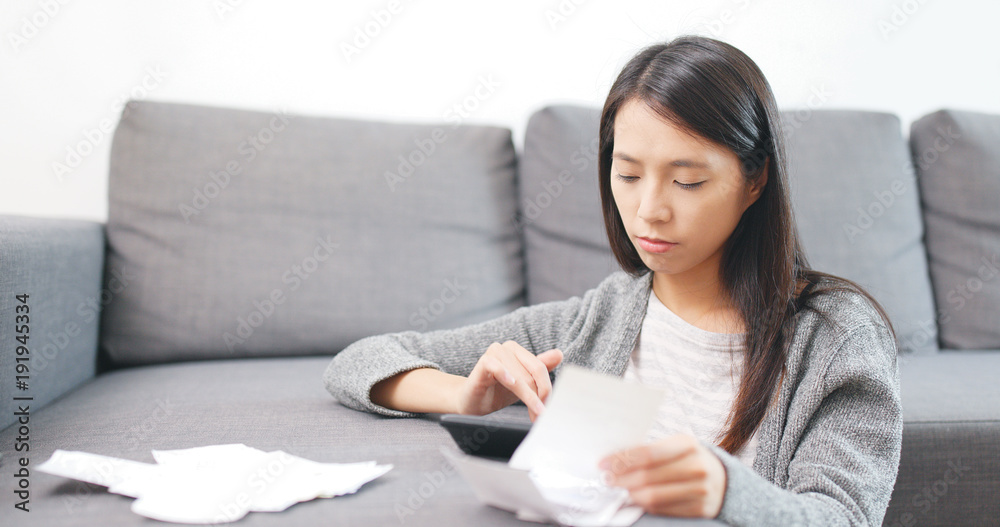 Housewife counting the calculator at home Housewife counting the calculator at home