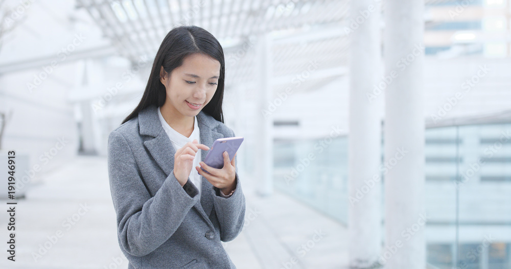 Obraz premium Businesswoman sending sms on cellphone at outdoor