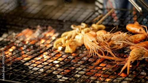 Shrimp grill in Night Food Market, Thailand Street Food. Preparation of large red shrimps on a grate. Jomtien, Pattaya, Thailand. photo
