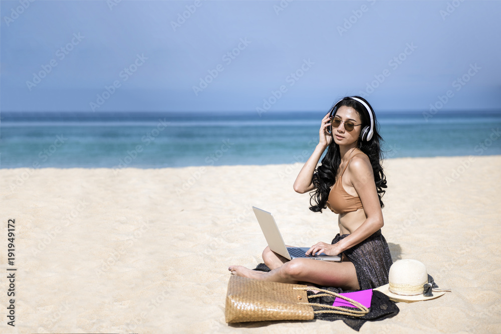 woman relax in vacation using laptop computer on the beach. Freelance work concep