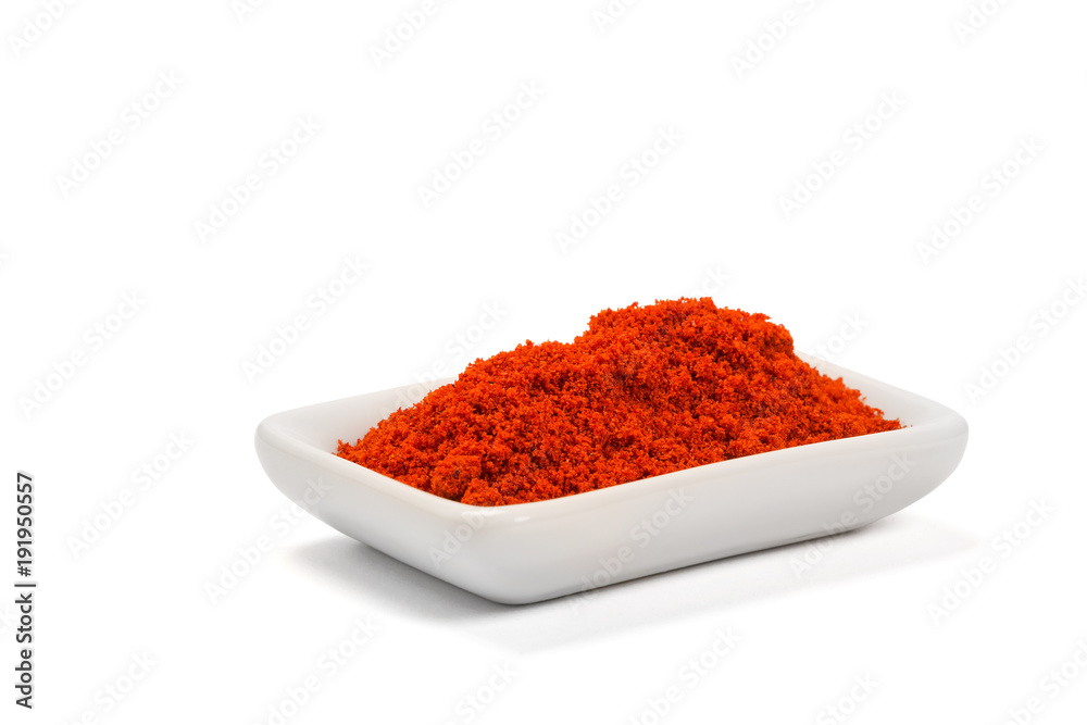 Paprika ground in a white bowl on white background. Paprika ground in a white bowl on white background.