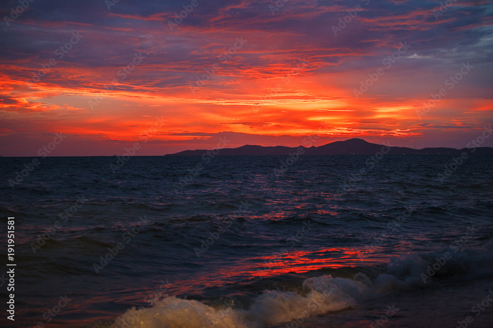 red sunset on the beach. Beach with waves at dusk.