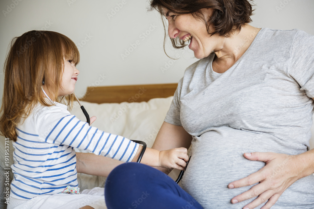 Pregnant mom spending time together with her daughter Pregnant mom spending time together with her daughter