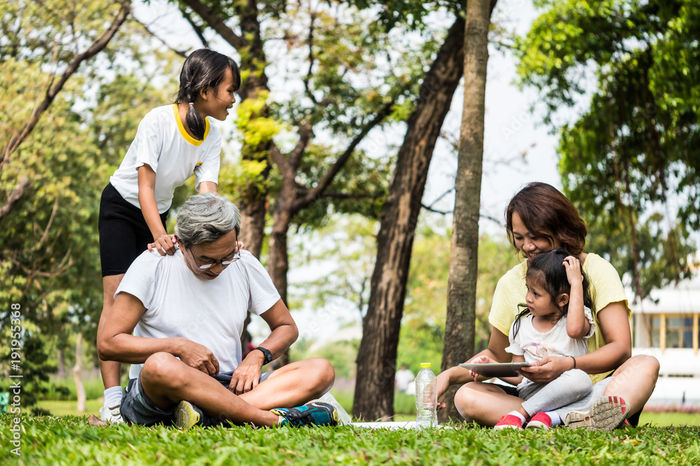 Activities in the family, Grandfather, mother and daughter relaxing in the park after exercise