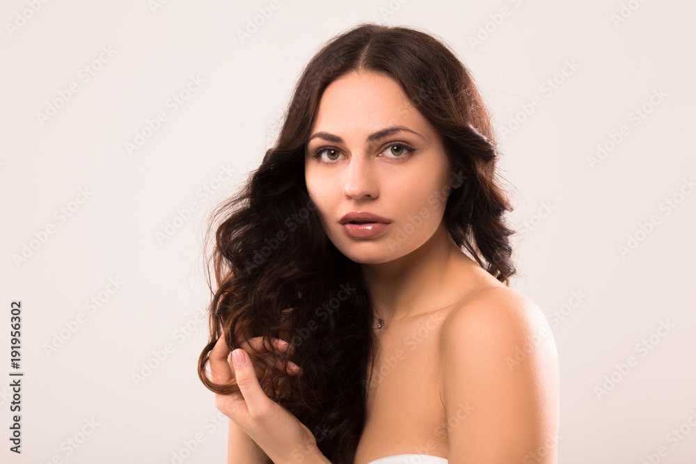 Attractive young brunette lady. Touching wavy hair. Attractive young brunette lady. Touching wavy hair.