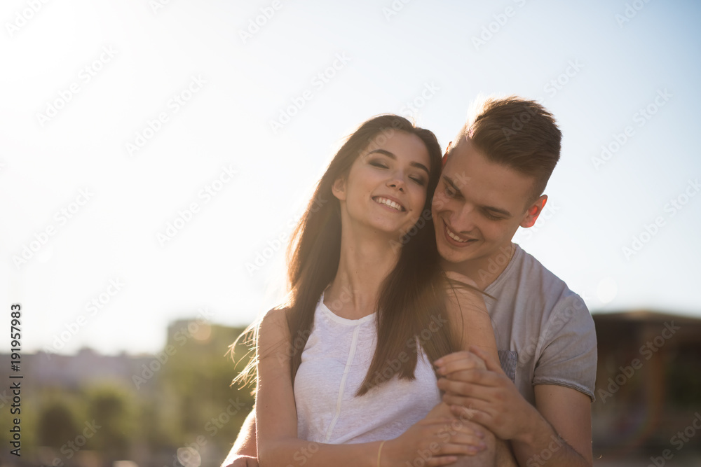 Cheerful young couple embracing outside