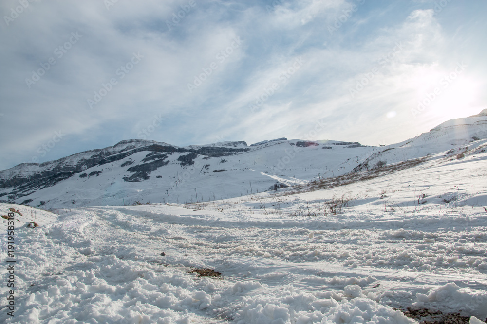 Panoramic view of mountain winter landscape with snowy peak.