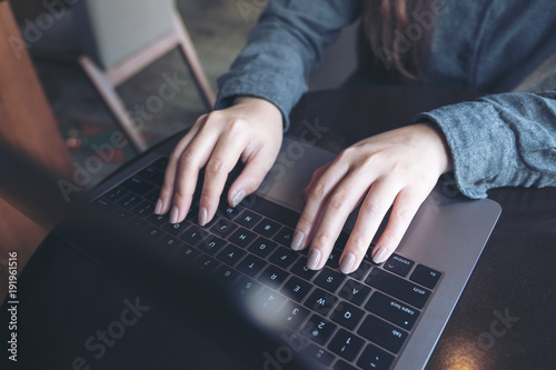Topview image of a business woman's hands working and typing on laptop keyboard on the table
