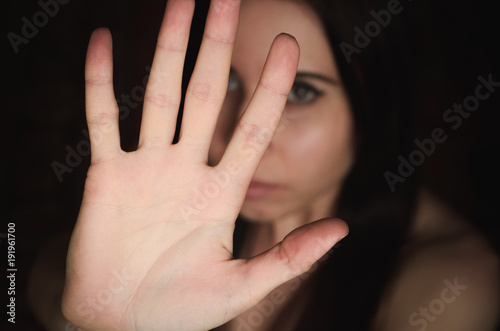 Young woman shows gesture of stop harassment