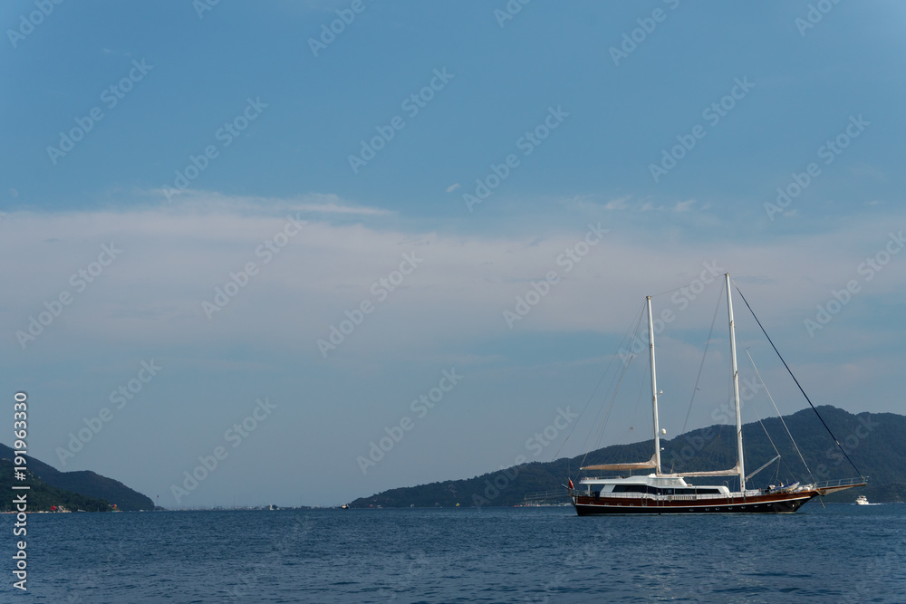 Sailing yacht in the sea in clear weathe against the background of beautiful mountains Sailing yacht in the sea in clear weathe against the background of beautiful mountains
