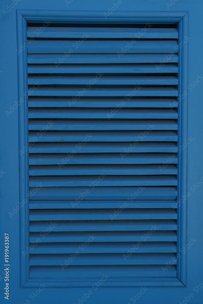 Large window closed by blue shutters. Vertical photo Large window closed by blue shutters. Vertical photo