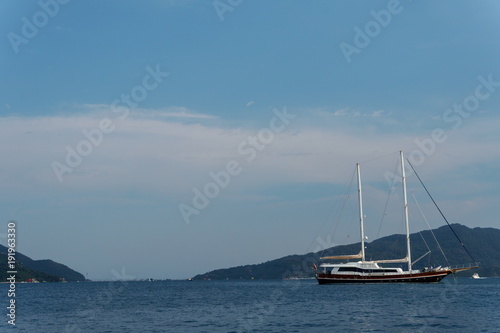 Sailing yacht in the sea in clear weathe against the background of beautiful mountains