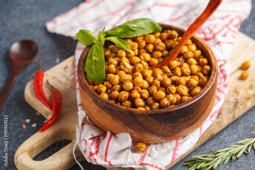 Healthy snack - baked spicy chickpeas in a wooden bowl. Healthy vegan food concept.