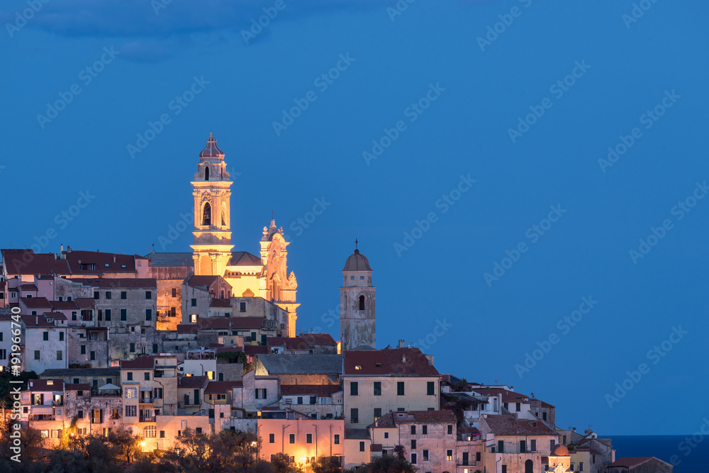 The old town of Cervo, Liguria, Italy, with the beautiful baroque church arising from the houses. Clear blue sky.