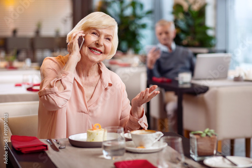 How are you. Enthusiastic vigorous mature woman calling while smiling and gesturing