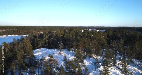 Winter lake, Cinema 4k aerial view over a islands, revealing a snowy frozen matildanjarvi sea, in Teijo national park, on a sunny winter evening dawn, in Varsinais-suomi, Finland photo