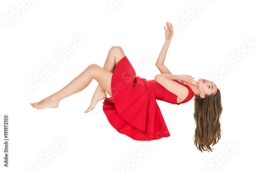 young woman in red dress falling with closed eyes isolated on white