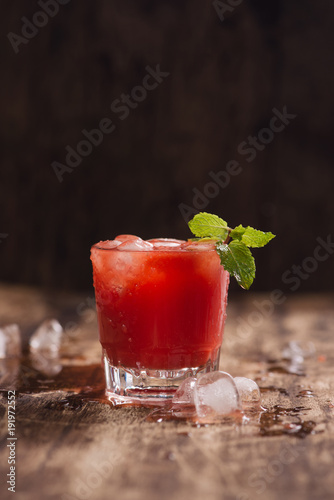 Refreshing summer watermelon juice in glasses on wooden table.