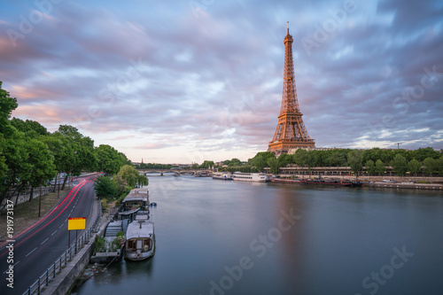 Long exposure photographyof the Eiffel Tower from Seine river in the evening time with parking boat at her bank