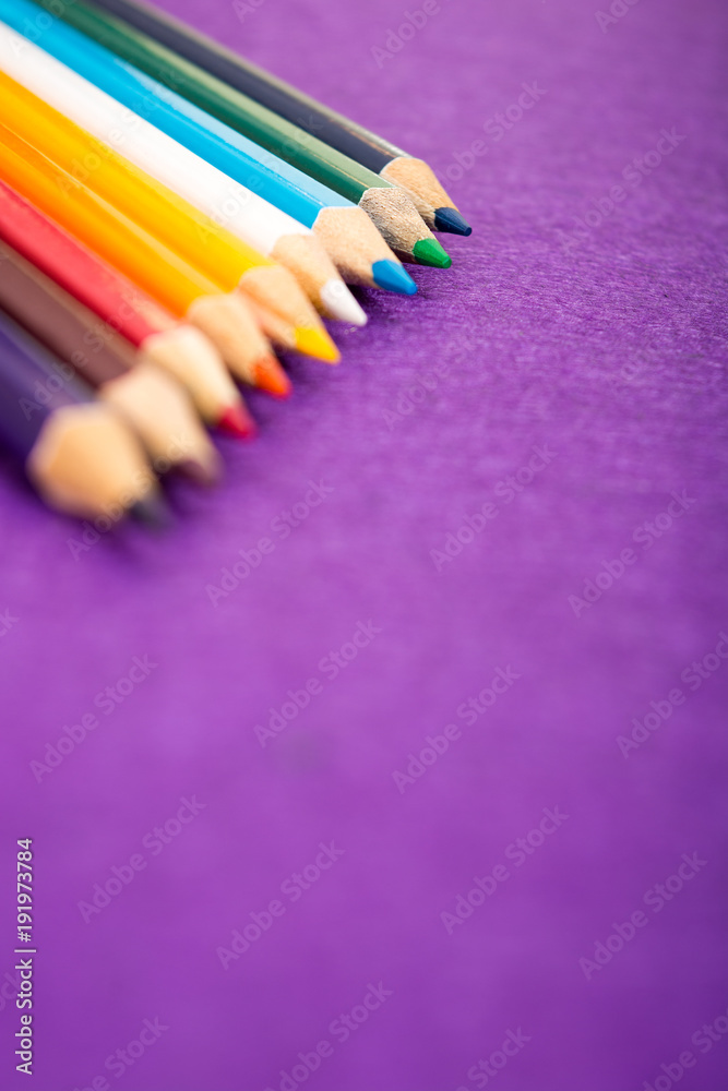 Nine multicolored pencils on a purple felt background. Different colored pencils with space for text. Back to school. Art lessons. Nine multicolored pencils on a purple felt background. Different colored pencils with space for text. Back to school. Art lessons.