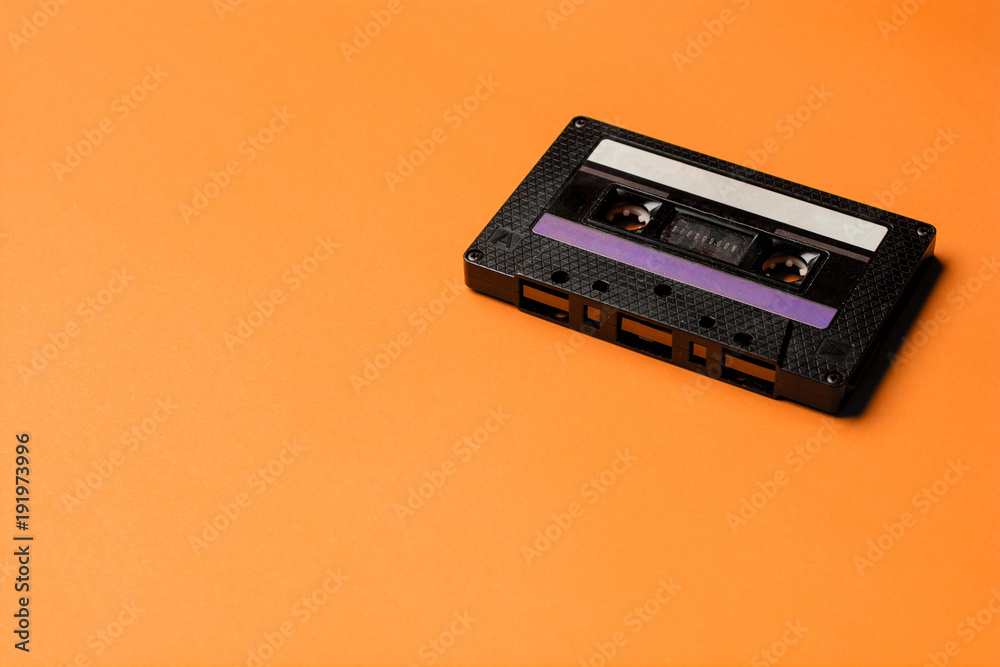 Obraz premium Retro cassette tape over orange background. top view. copy space