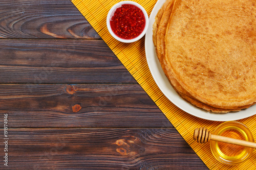 Hot pancakes with sprinkled maple syrup and raspberry jam. The good you breakfast. top view photo