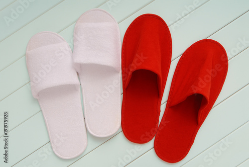 red and white slippers from hotel, red and white slippers from airplane are on white wooden floor, home slippers are on white background, home footwear