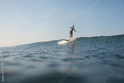 sportswoman surfing the wave on surf board in ocean