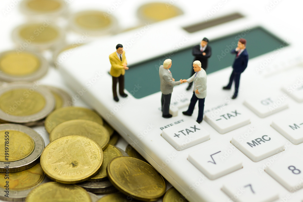 Miniature people: Businessman stand on calculator, calculation tax monthly/yearly. Image use for Tax calculation every year for everyone. Miniature people: Businessman stand on calculator, calculation tax monthly/yearly. Image use for Tax calculation every year for everyone.