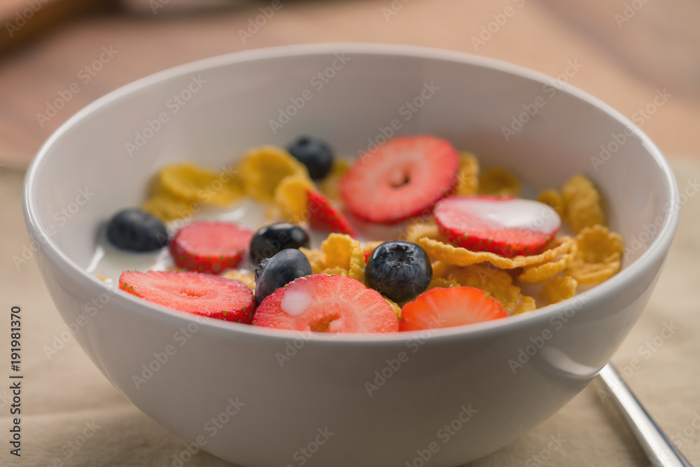 corn flakes with berries in white bowl for breakfast on table corn flakes with berries in white bowl for breakfast on table