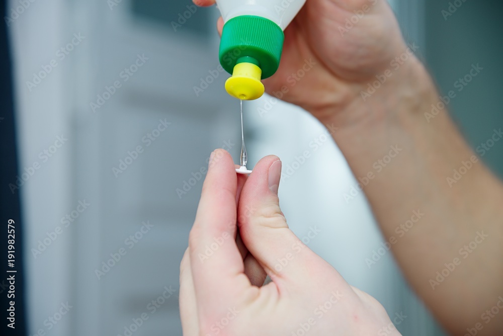 Man glue the broken plastic with glue. White skin, dark hair Man glue the broken plastic with glue. White skin, dark hair