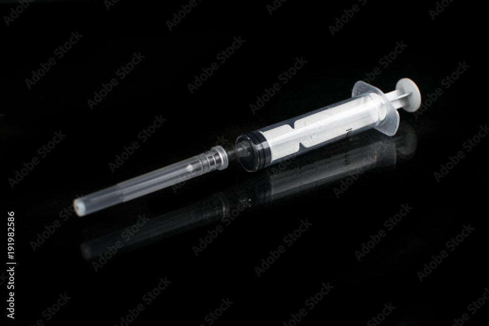 medical syringe on black background with reflection medical syringe on black background with reflection