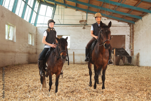 Girl And Young Woman In Indoor Riding Arena © nullplus