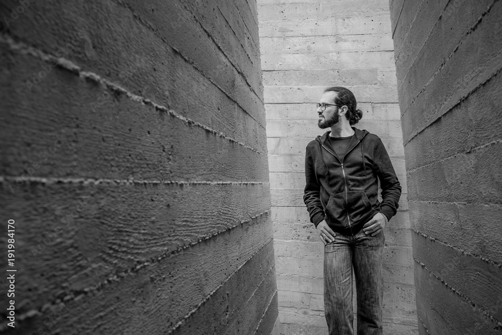 White young handsome man standing near the wall and look up. Portrait of fashion guy in blue jeans and casual wear smiling White young handsome man standing near the wall and look up. Portrait of fashion guy in blue jeans and casual wear smiling