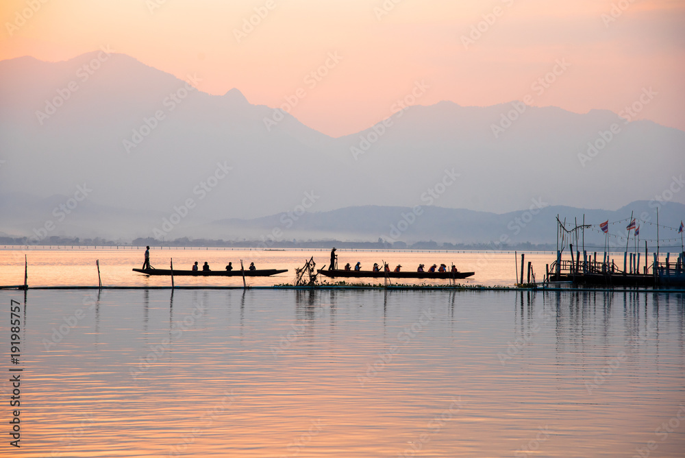 landscape view - boatman paddle boat in the lagoon lake.(Kwan phayao) in evenign time at phayao thailand landscape view - boatman paddle boat in the lagoon lake.(Kwan phayao) in evenign time at phayao thailand